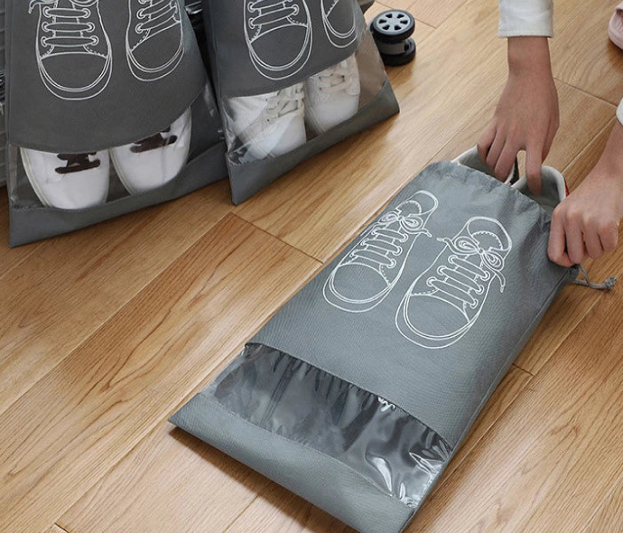 a person holding a grey bag with white shoes inside